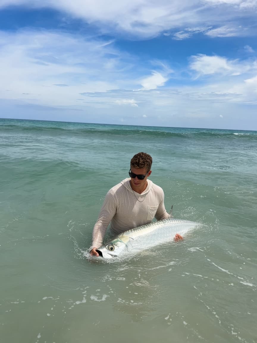 Landing a tarpon in the surf in the Twin Fin sun hoodie